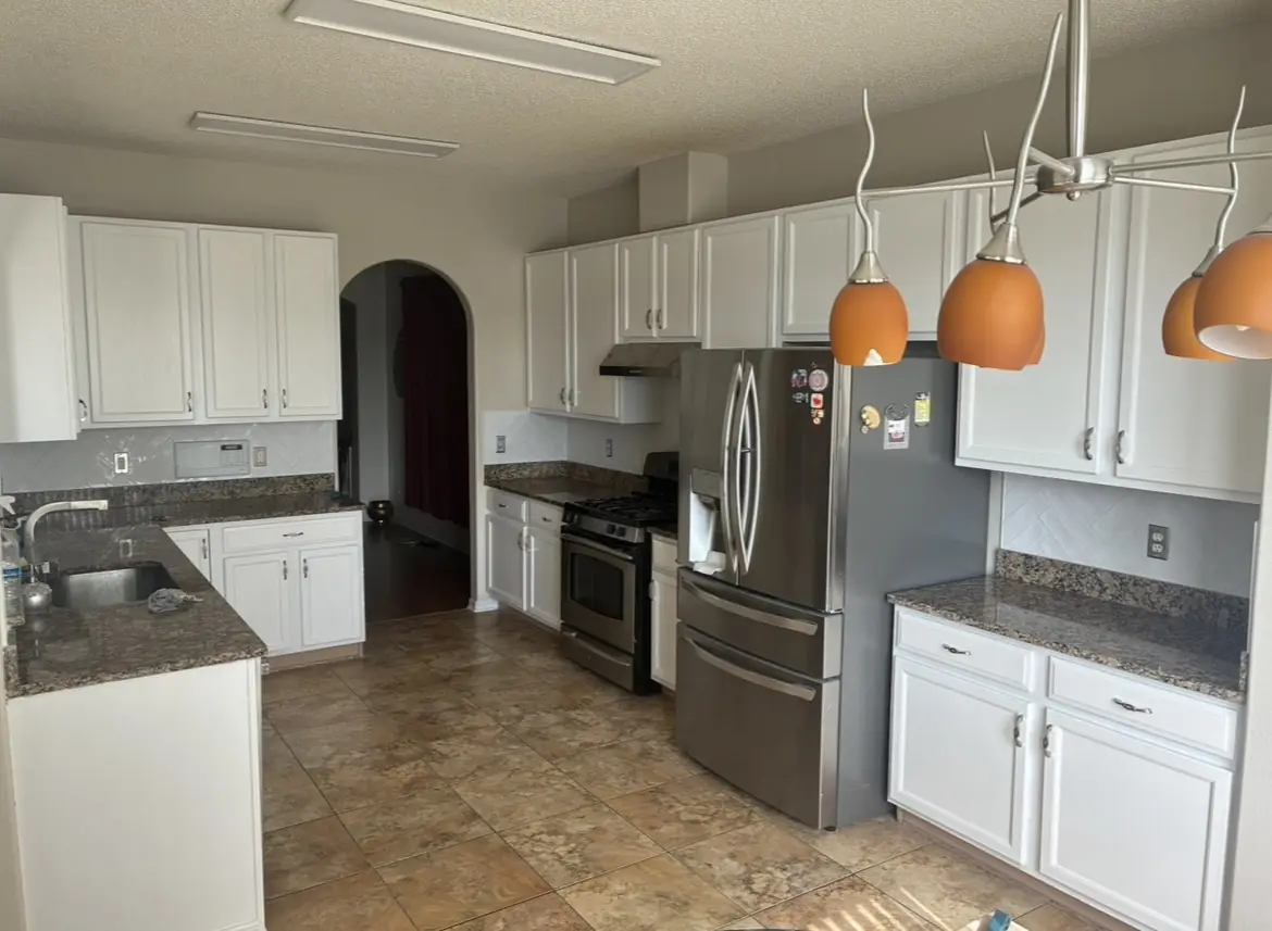 Freshly refinished cabinets and herringbone backsplash in a renewed kitchen
